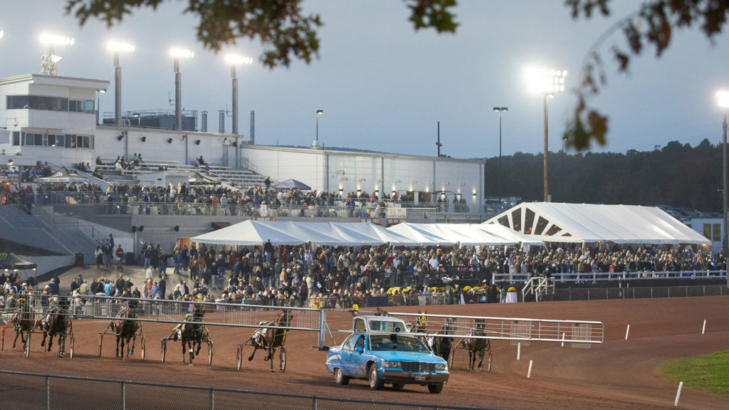 Harness racing with pacer car in foreground