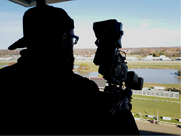 Man filming a horse racing event
